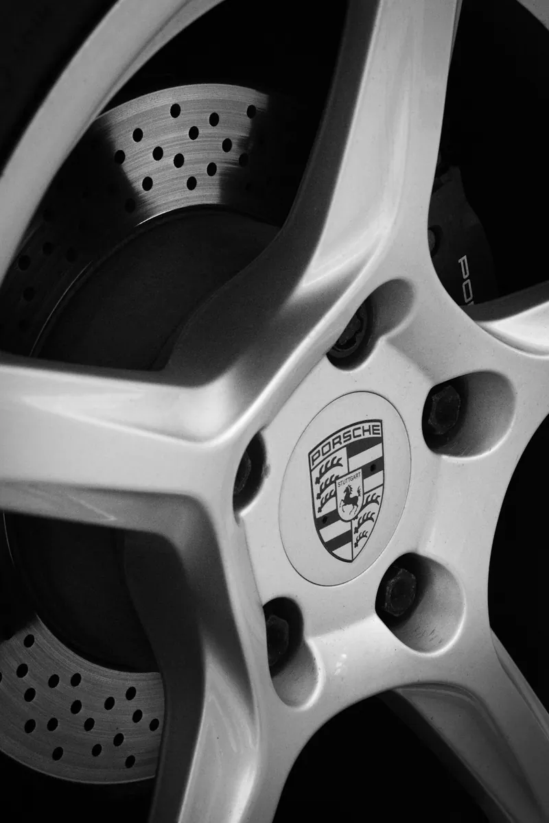 A silver alloy wheel in front of a drilled brake disc