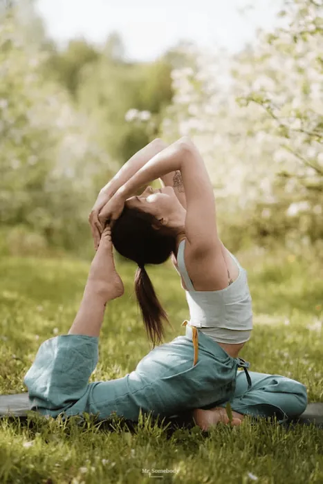 A woman in a yoga backbend on the grass