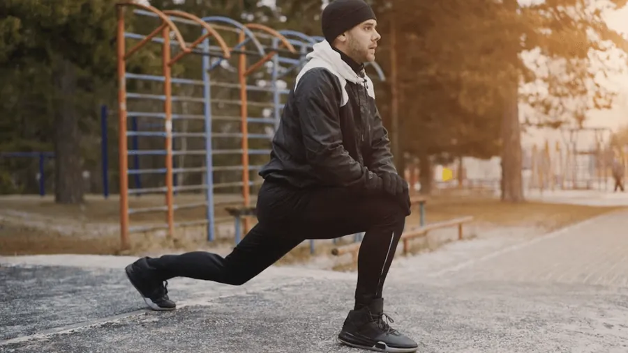 A man stretching in a lunge outdoors