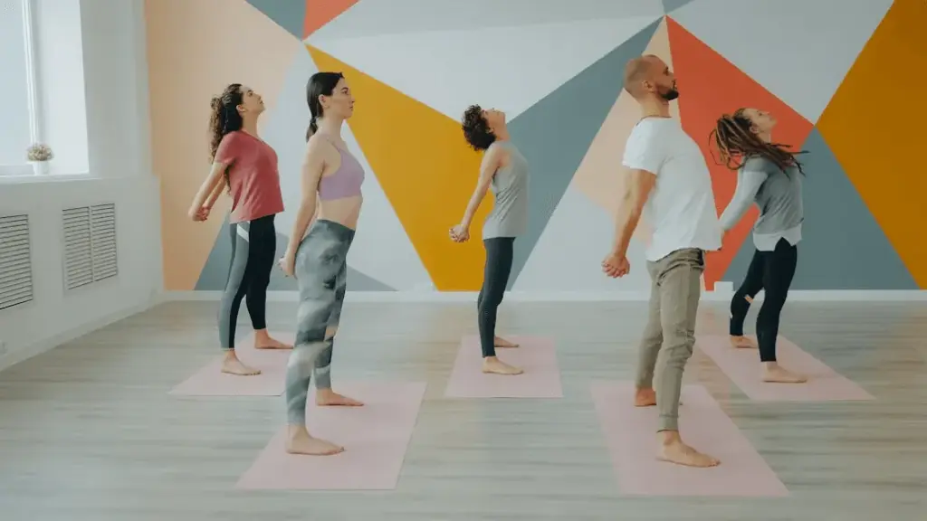 A group stretching in front of a colourful wall