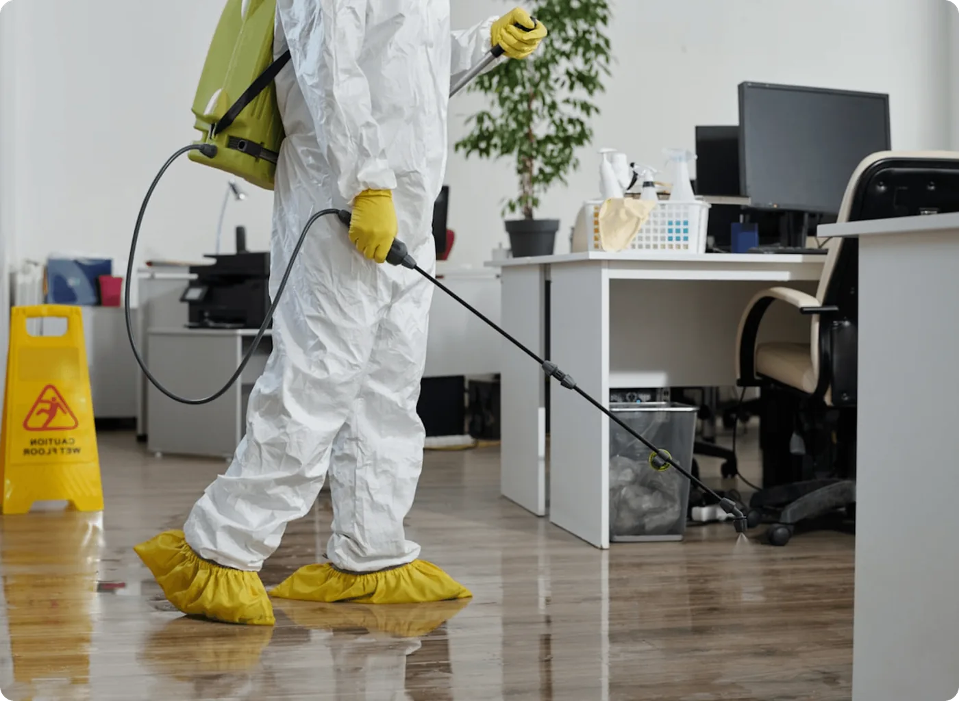 A technician in a protective suit treating an office