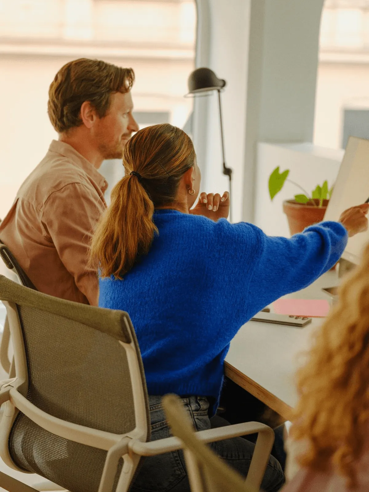 A consultant and a client pointing at notes during a working session