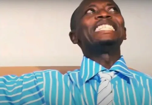 A laughing man in a blue striped shirt