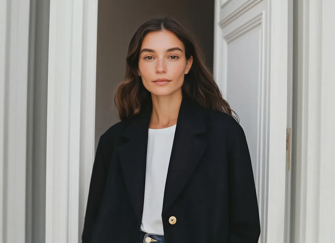 Nova Cross in a black coat, standing in a doorway
