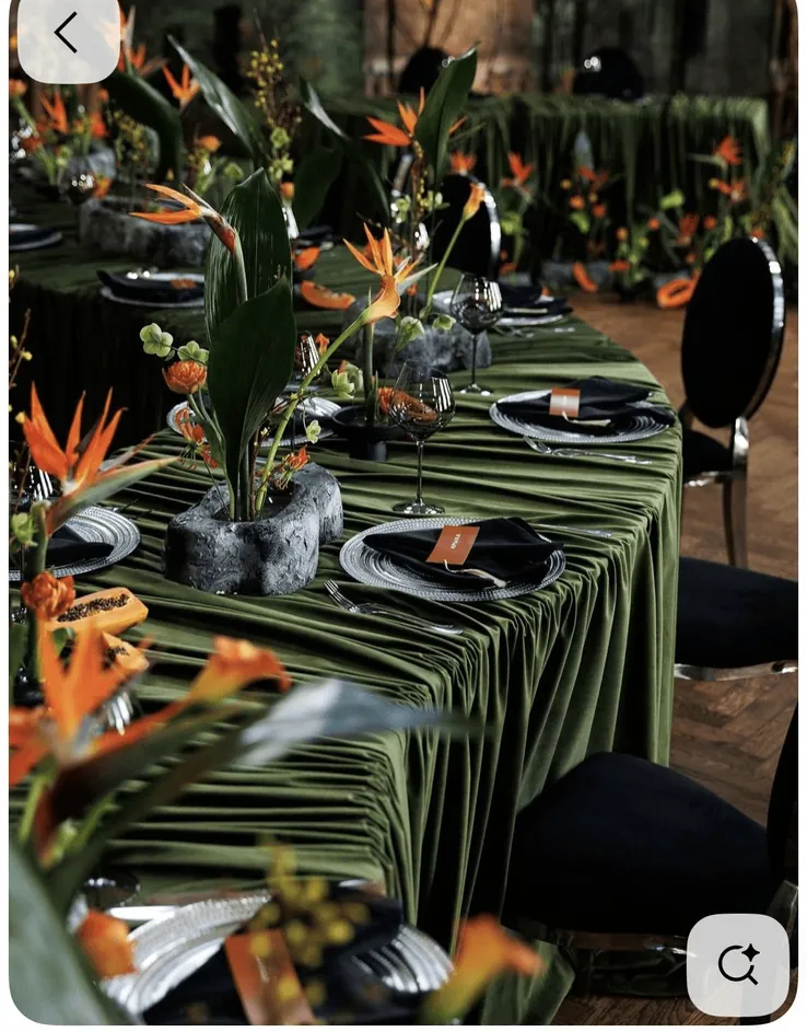 A table dressed in green velvet with tropical flowers