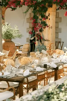 A stone patio table with garden flowers and bougainvillea