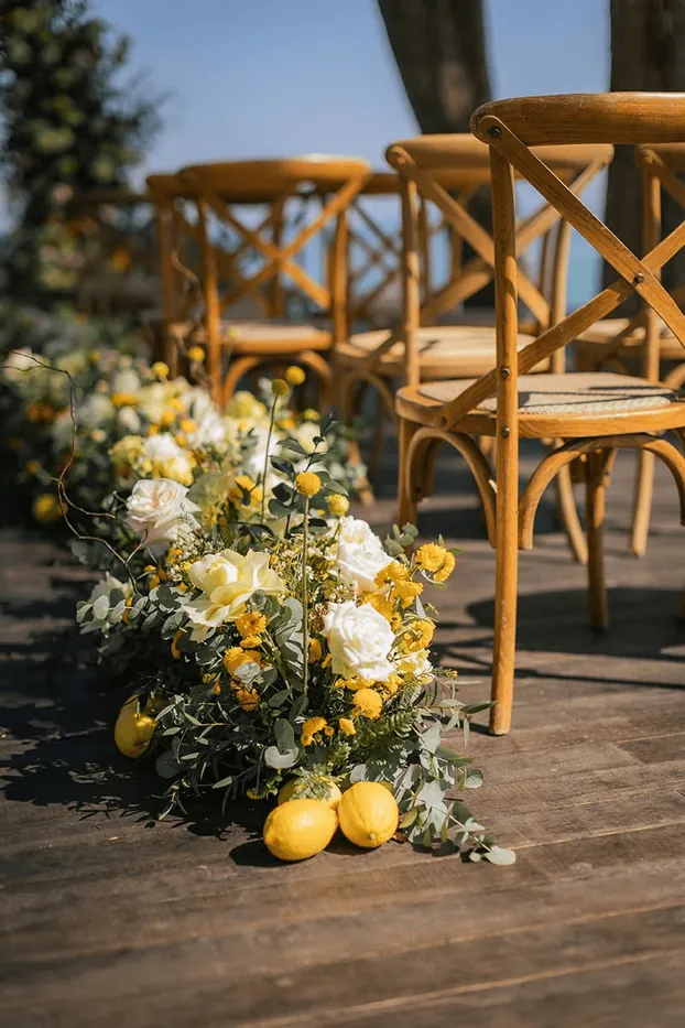 A terrace with yellow flowers and lemons beside wooden chairs