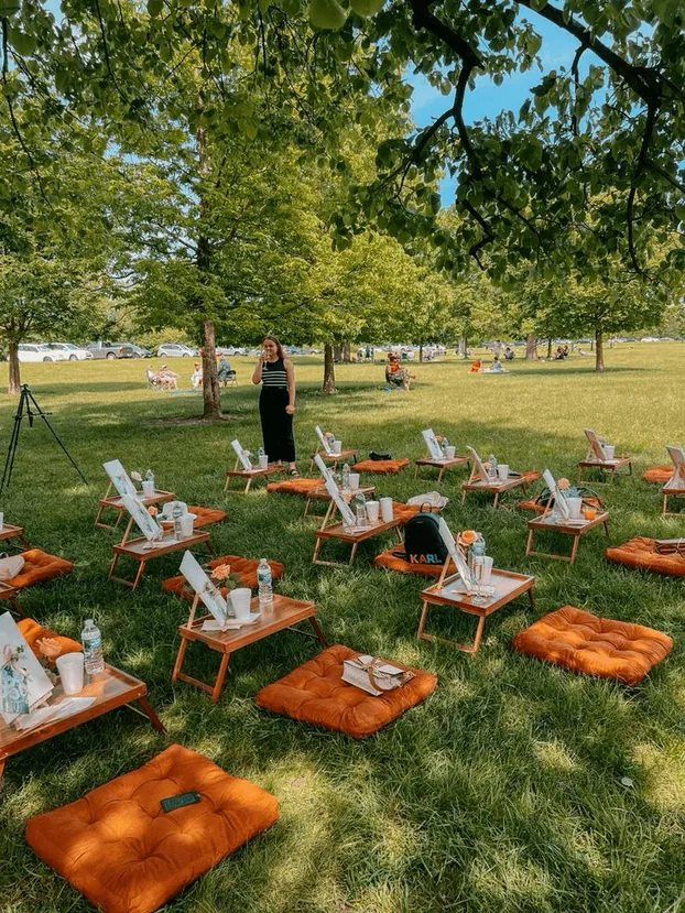 Low lounge seating with orange cushions on a lawn