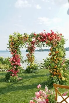 A floral arch over a lakeside lawn