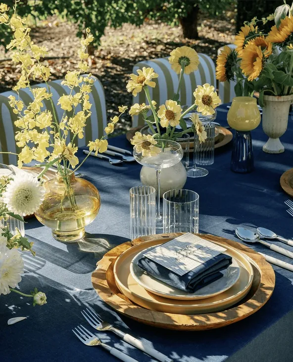 A blue and gold table setting with yellow flowers