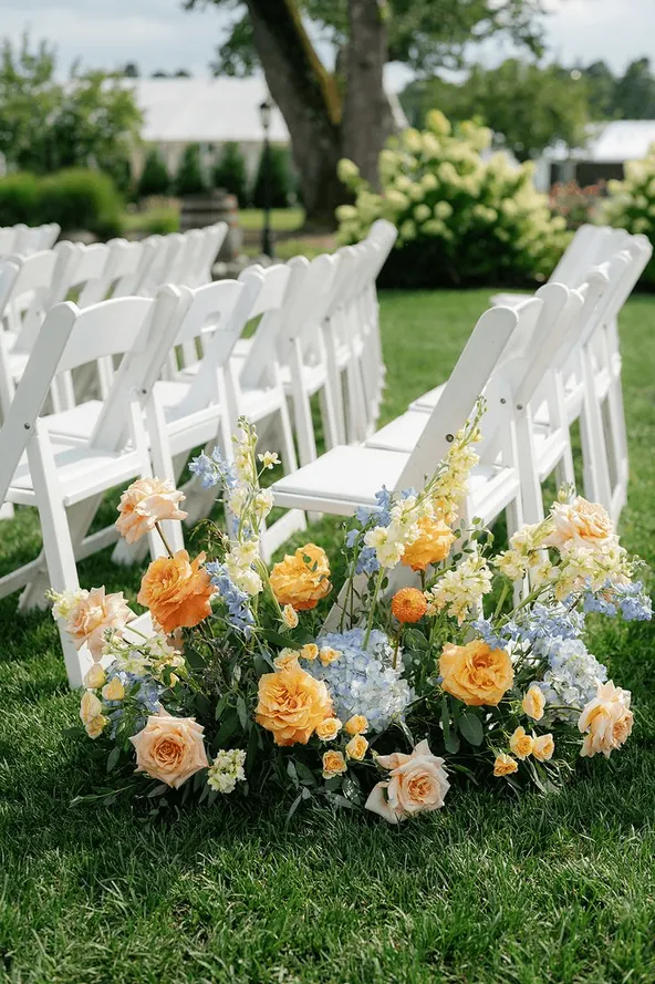 White garden chairs beside a meadow of spring flowers