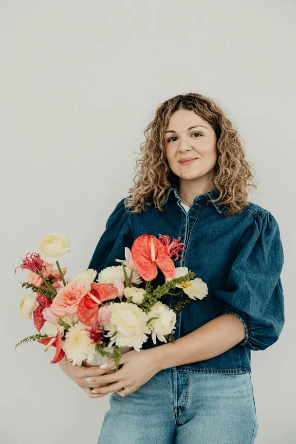 Amelia Rose holding a bouquet of red and cream flowers