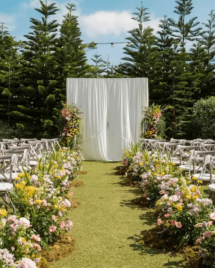 A wedding ceremony aisle lined with white flowers