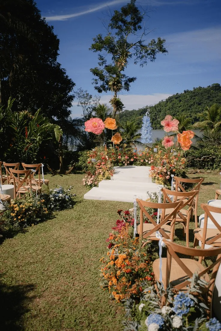 A garden path lined with orange flowers and wooden chairs