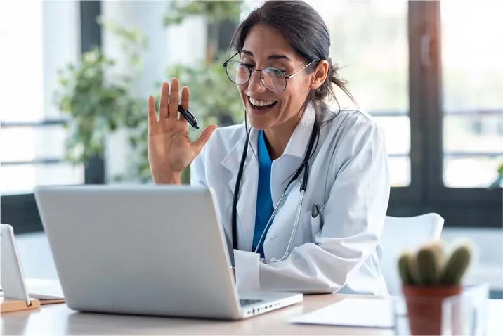 A doctor waving on a video call