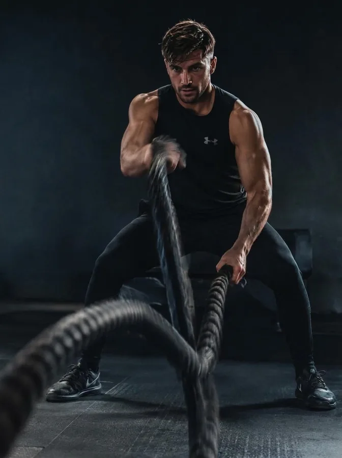 An athlete working with battle ropes during a circuit class