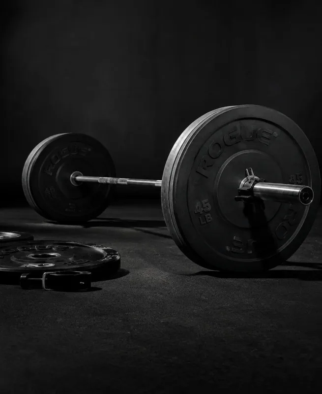 A loaded barbell with bumper plates on a gym floor