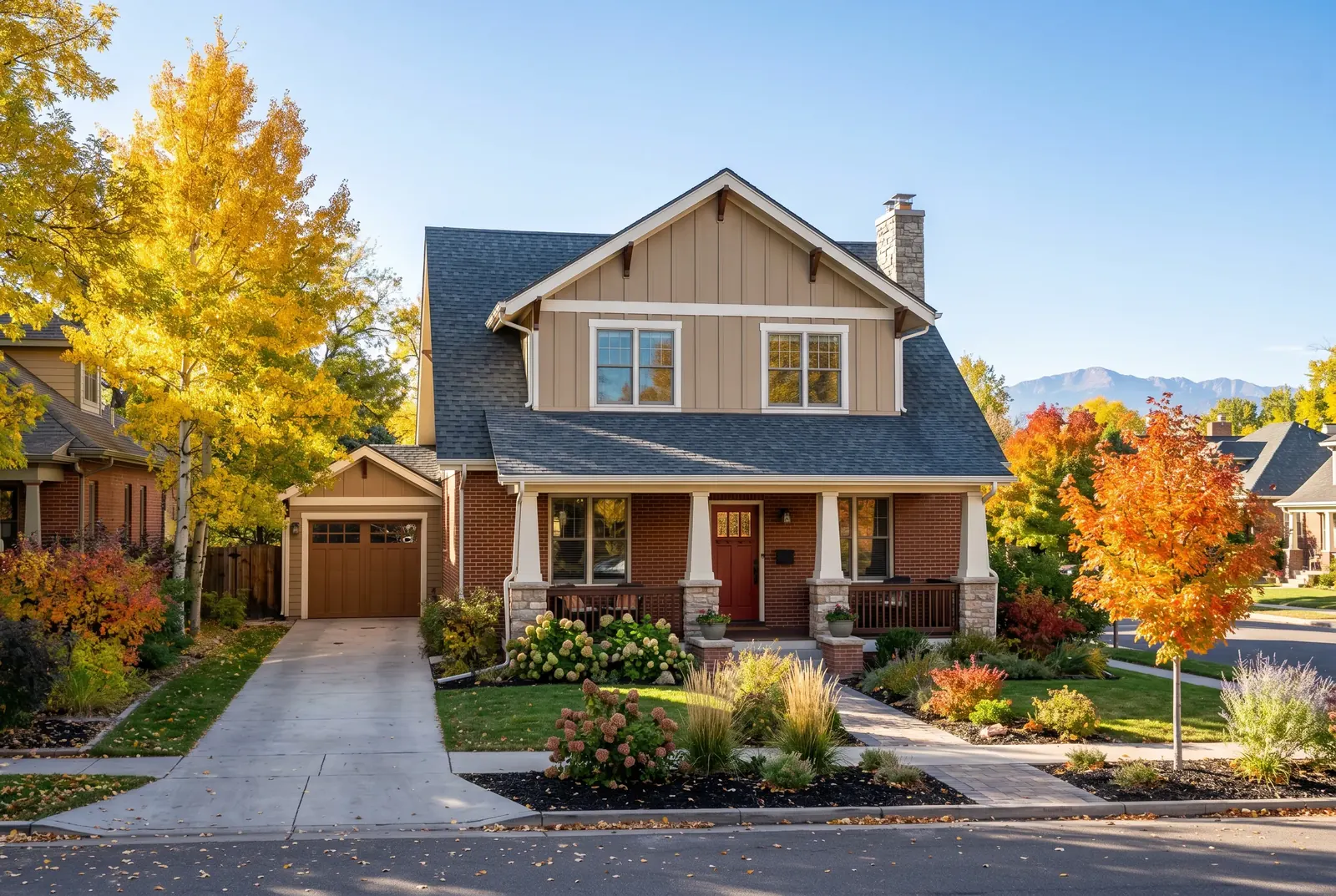 A two-story family home with a front porch among autumn trees