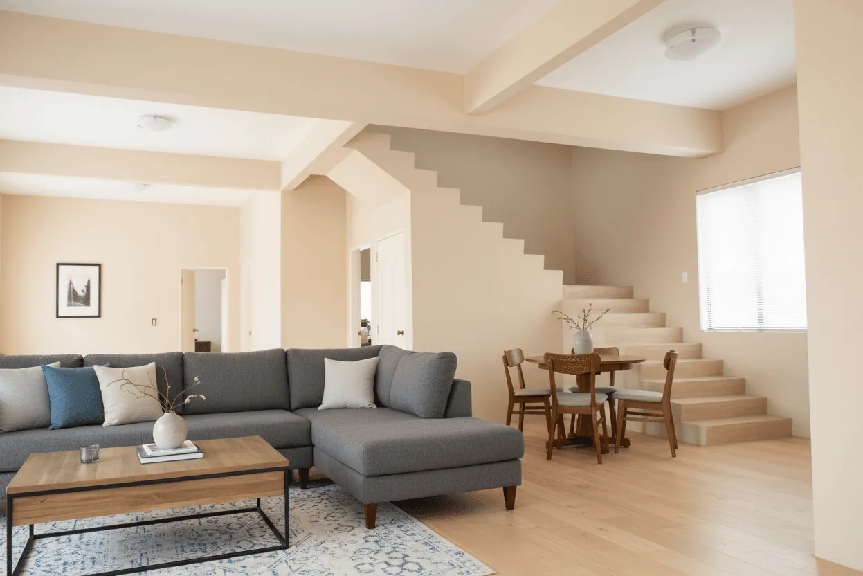 A finished living room with a corner sofa beside a staircase