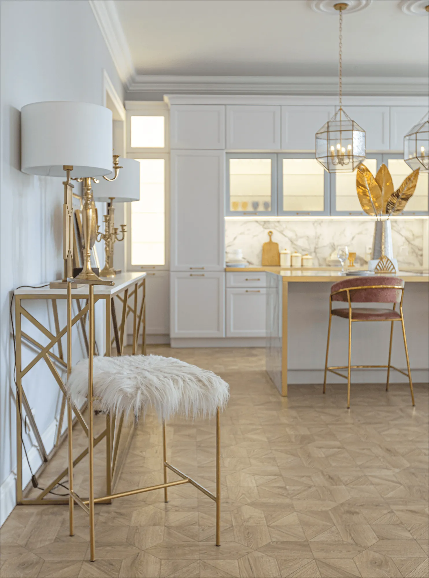 A gold console table and a fur stool in a white kitchen