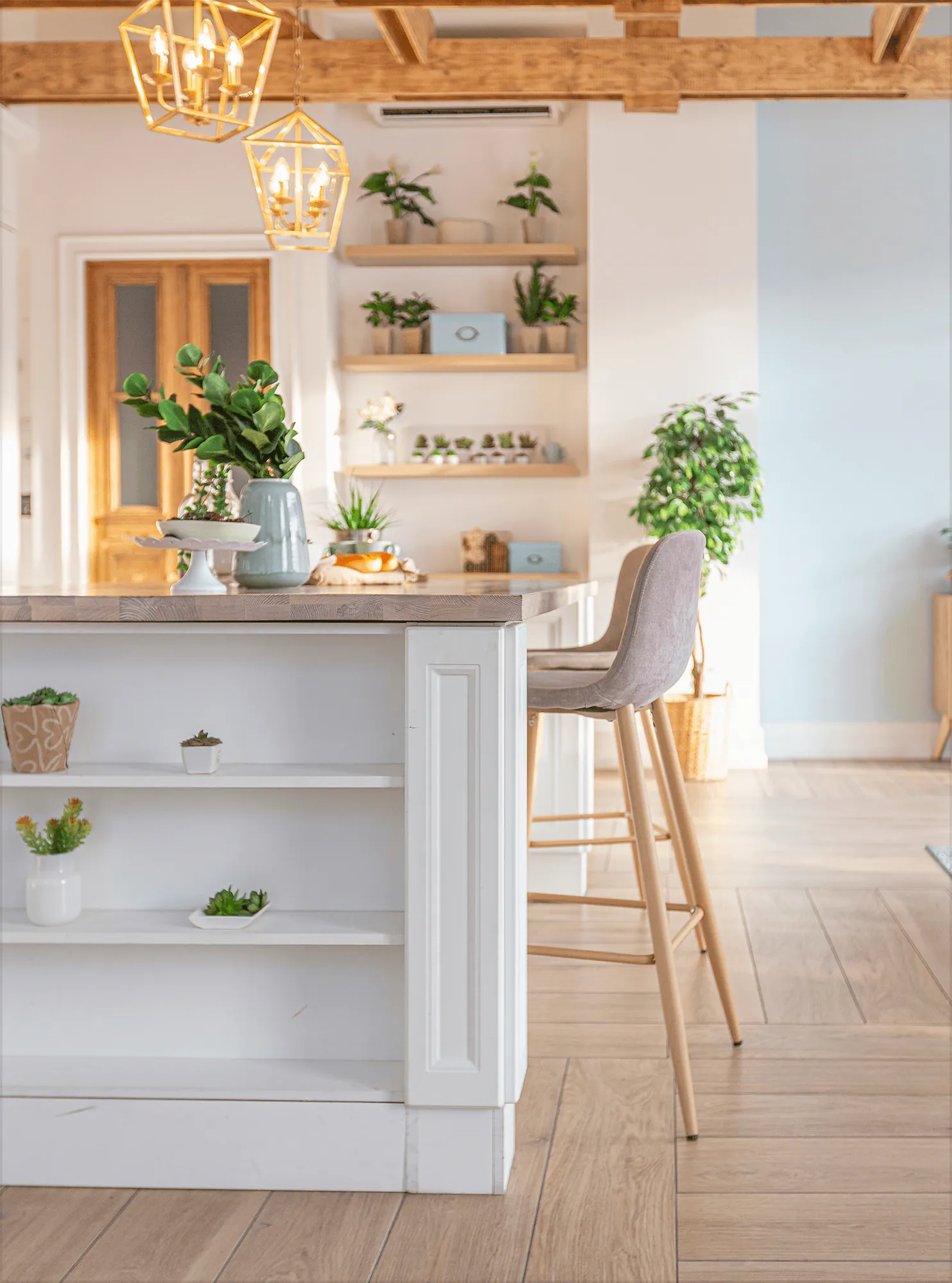 A white kitchen island with open shelves and a bar stool