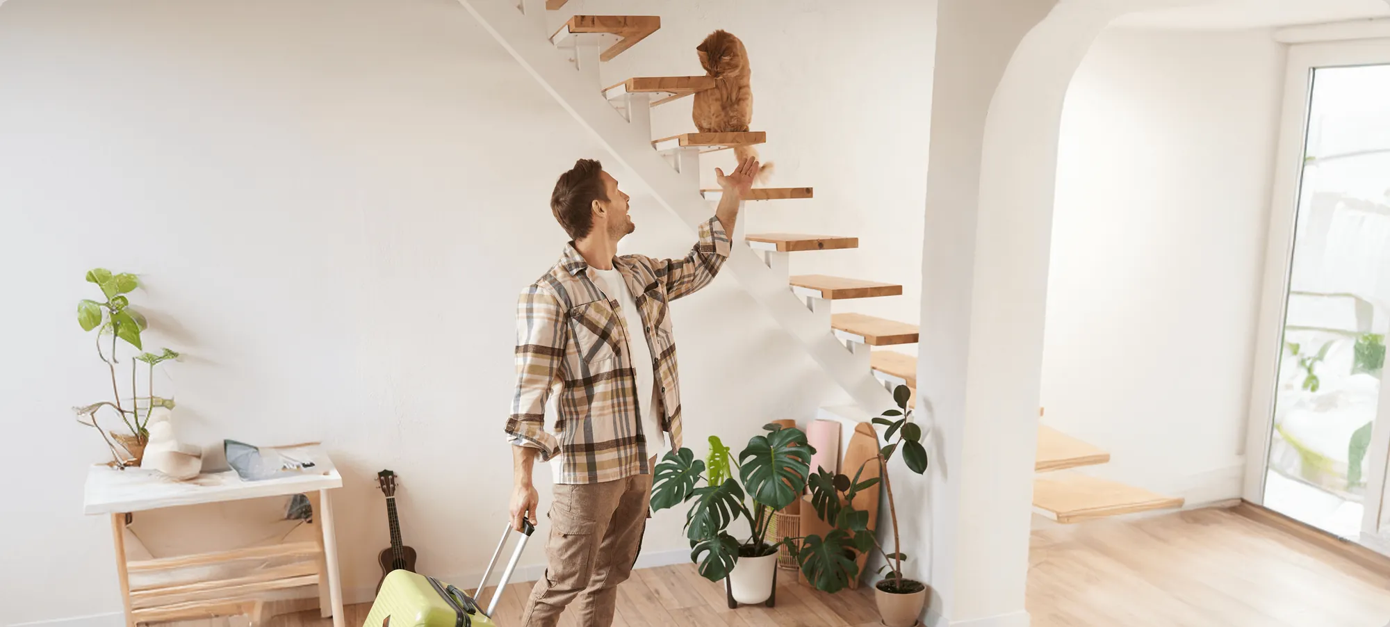 A man arranging plants on the shelves under a staircase
