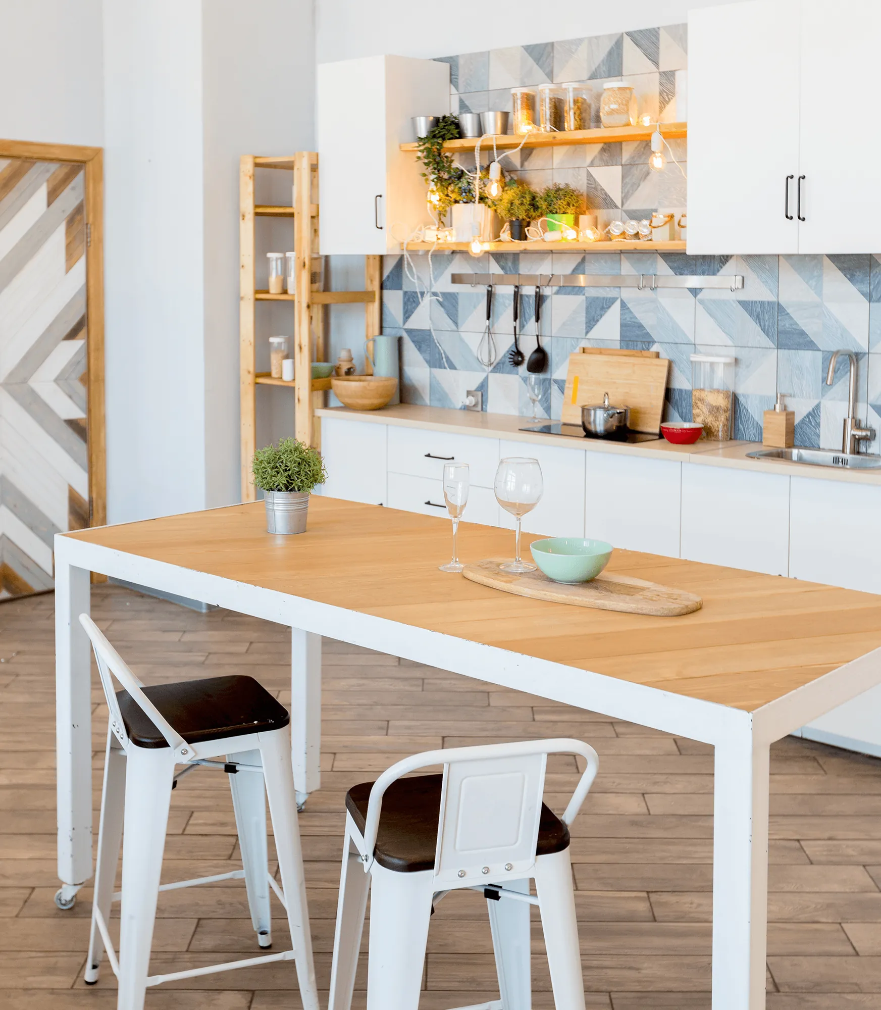 A white dining table with a wooden top beside open shelves