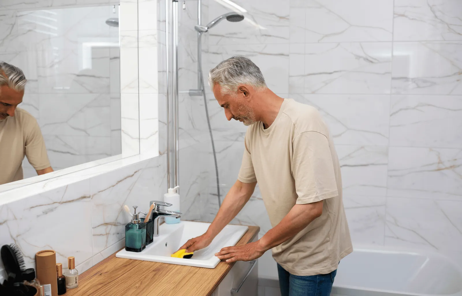 A man fitting a basin in a marble bathroom