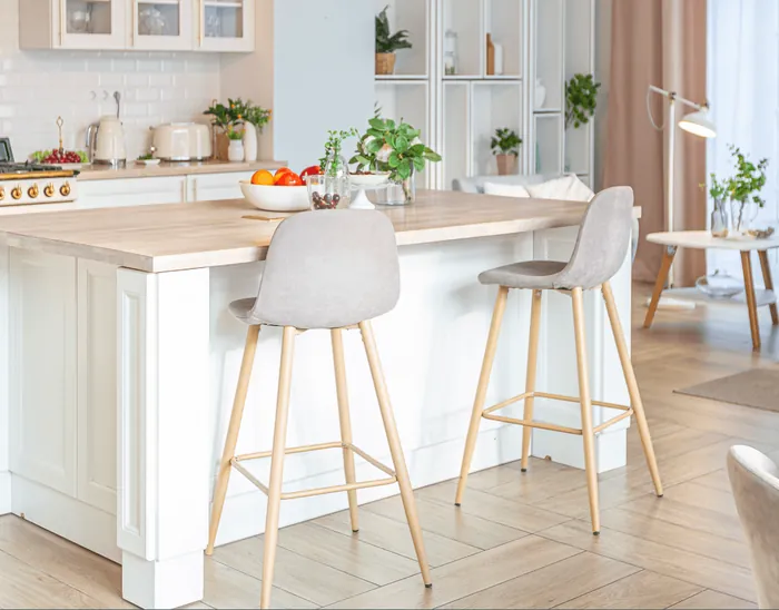 A kitchen island with grey bar stools