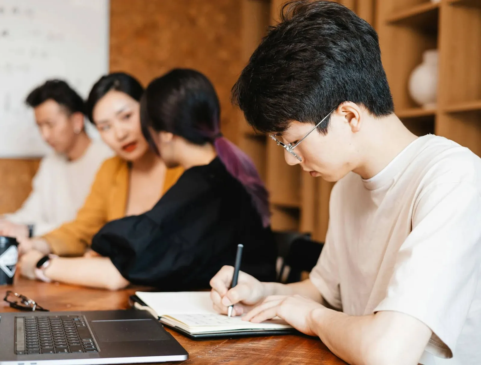 Colleagues taking notes around a table