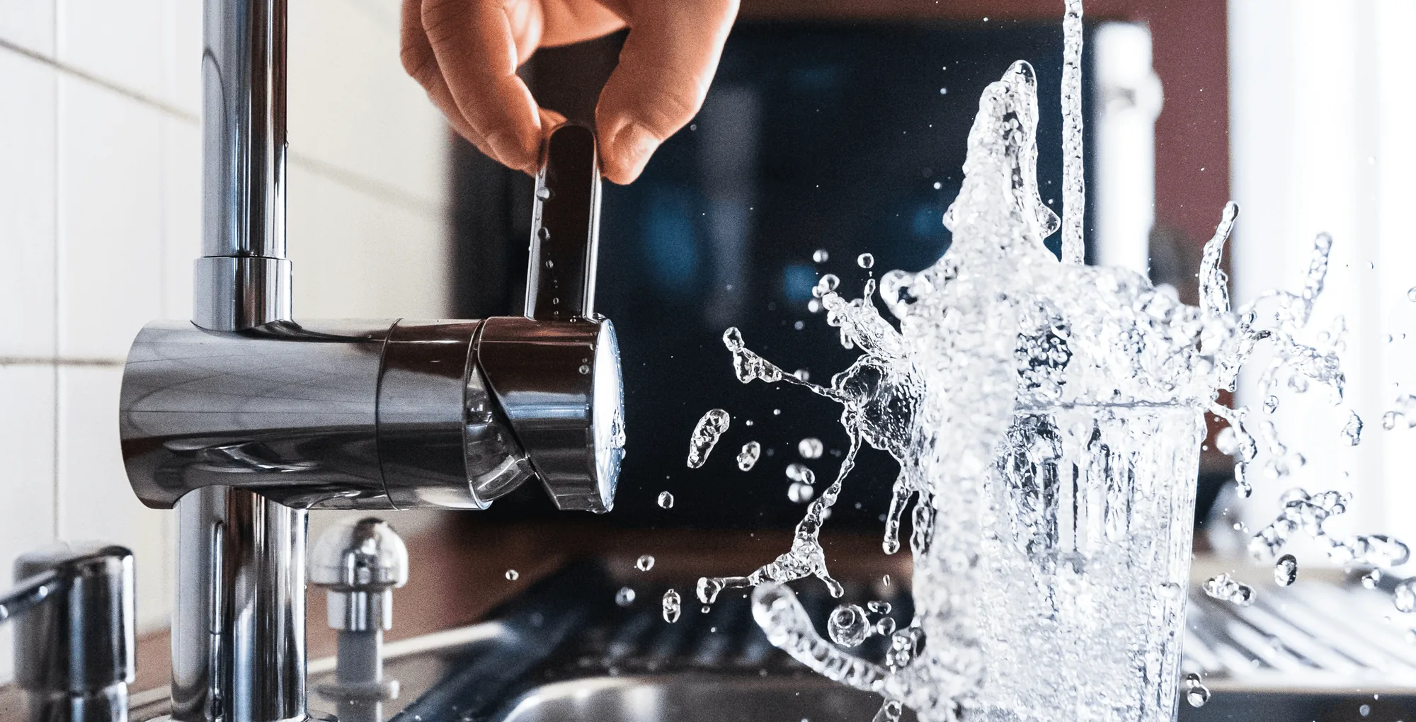 Water splashing from a tap into a glass