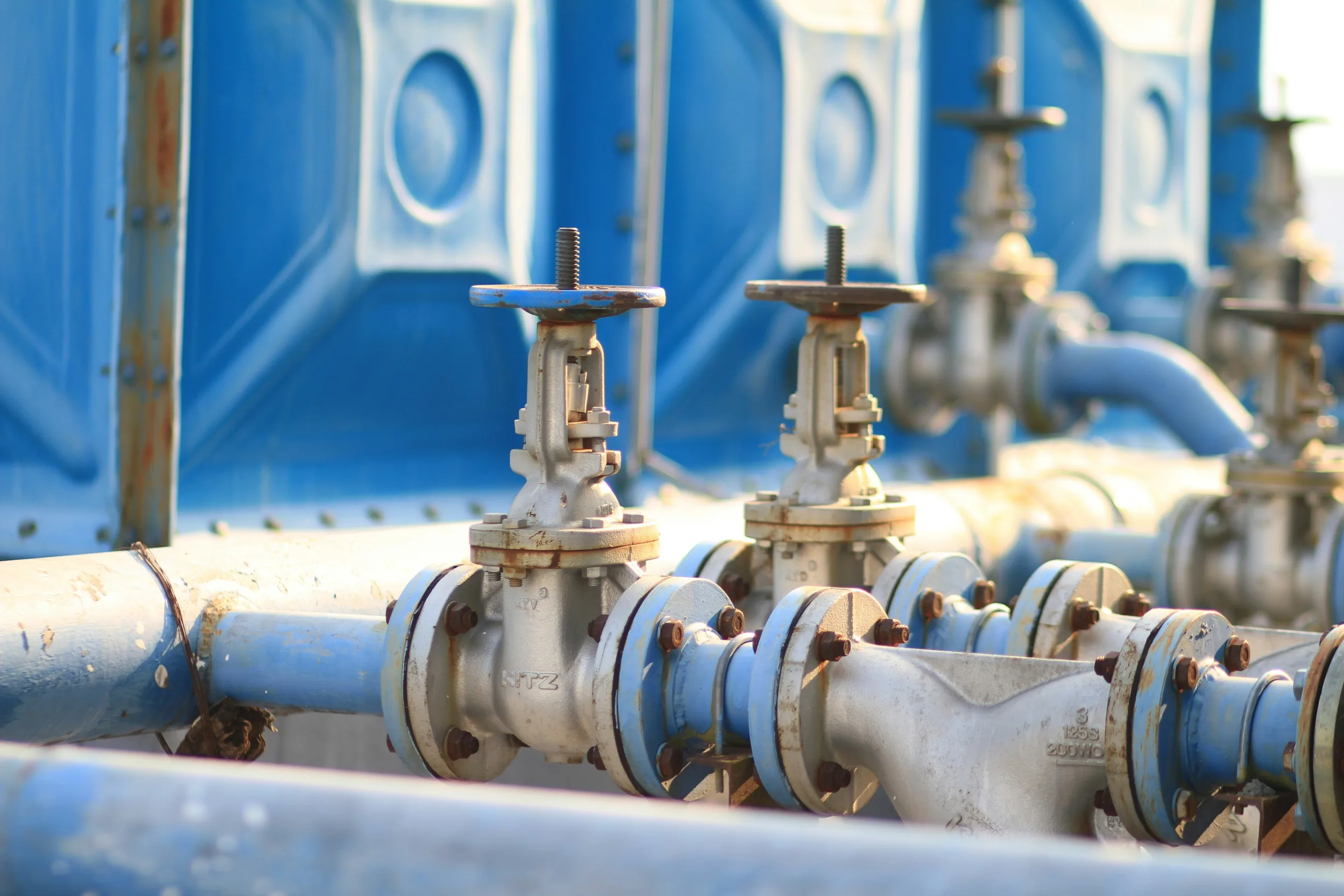 A row of valves on blue pipes