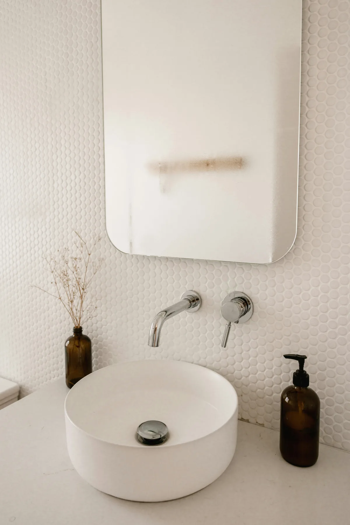 A white water heater on a tiled wall
