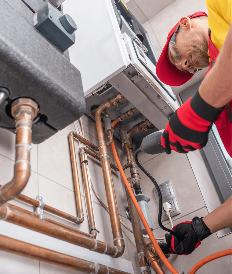 A plumber fitting copper pipes to a boiler