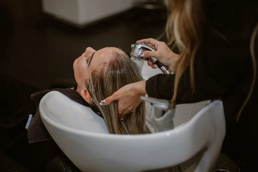 A client leaning back at the basin while her hair is washed