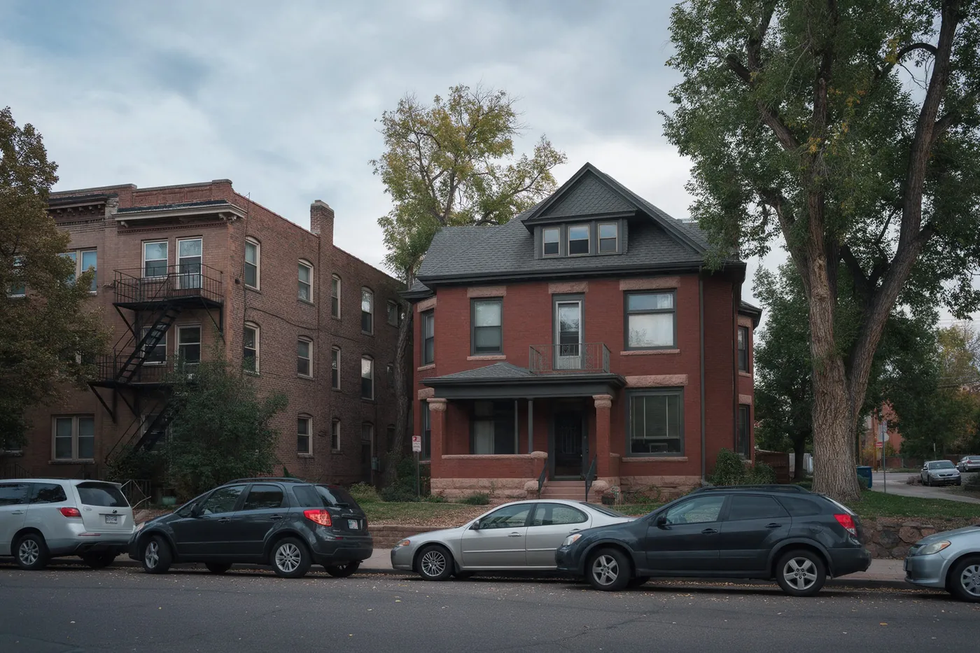 Brick apartment houses and an old mansion along a Capitol Hill street