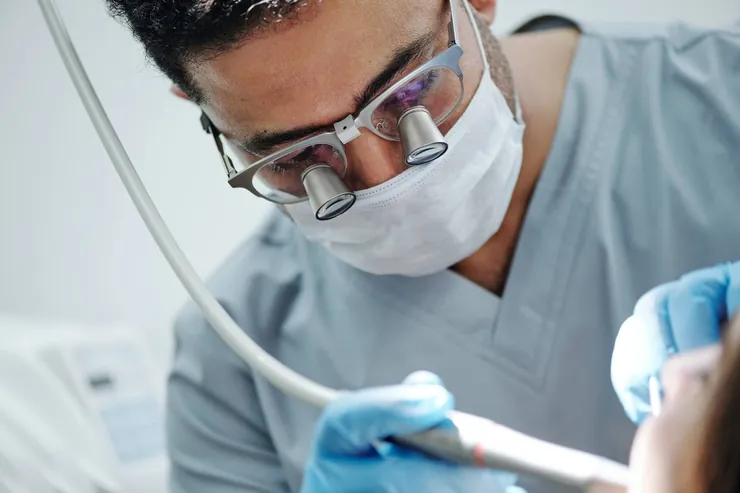 A dentist wearing magnifying loupes