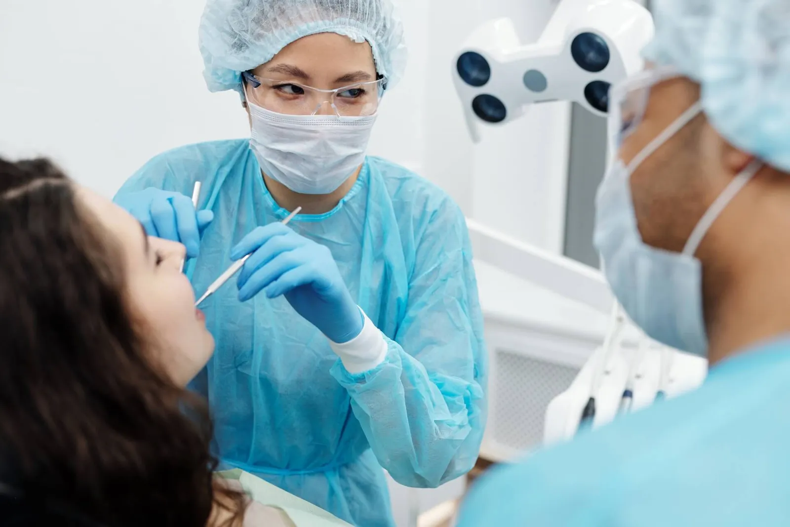 A dentist in a mask treating a patient