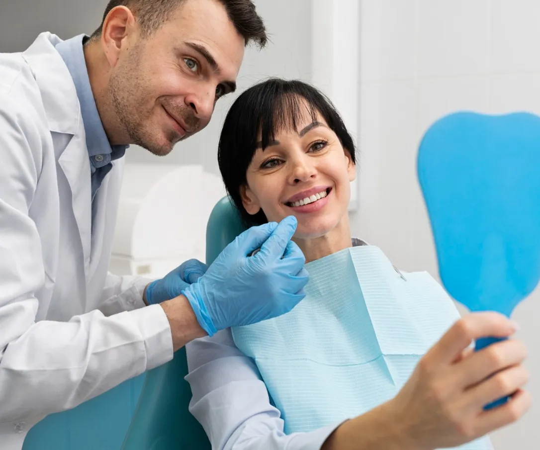 A dentist and a smiling patient with a hand mirror