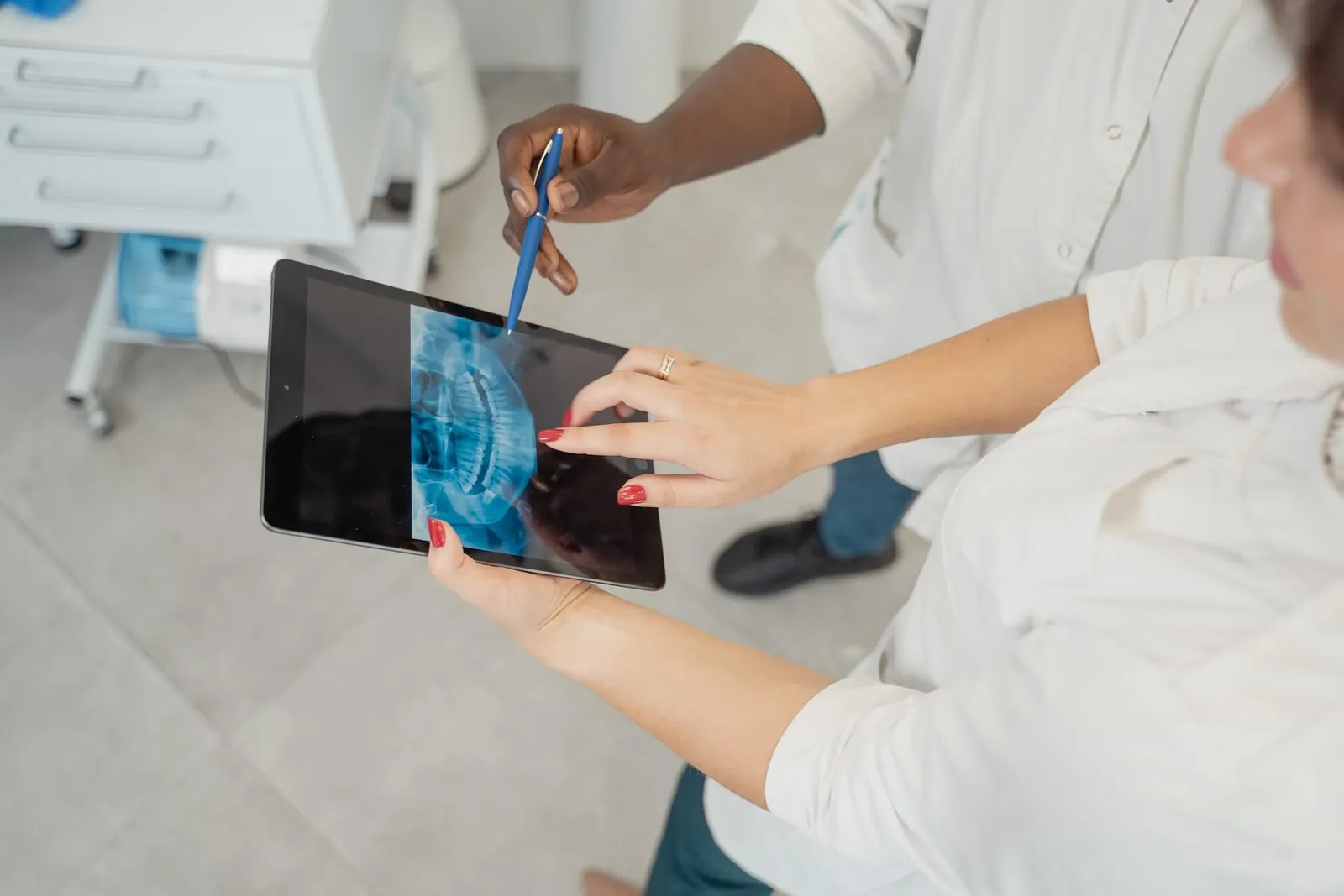 A dentist showing a patient her x-ray on a tablet