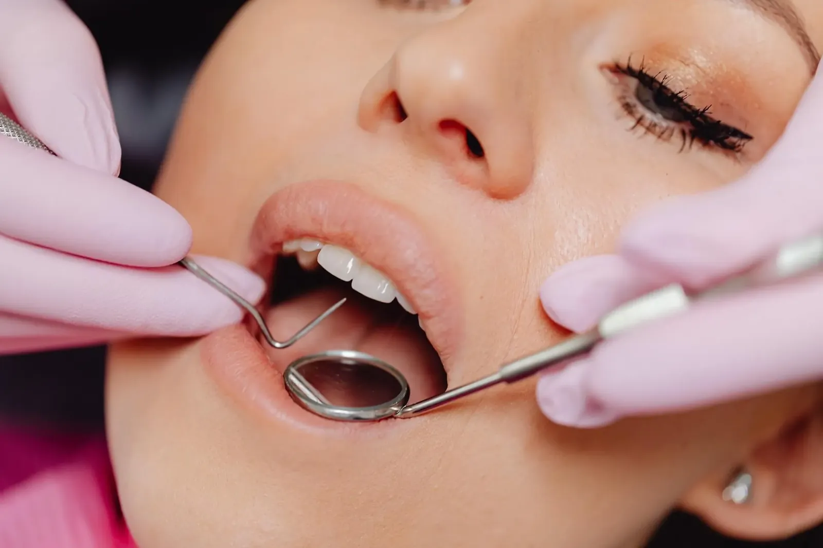 A dentist examining a patient’s teeth with a mirror