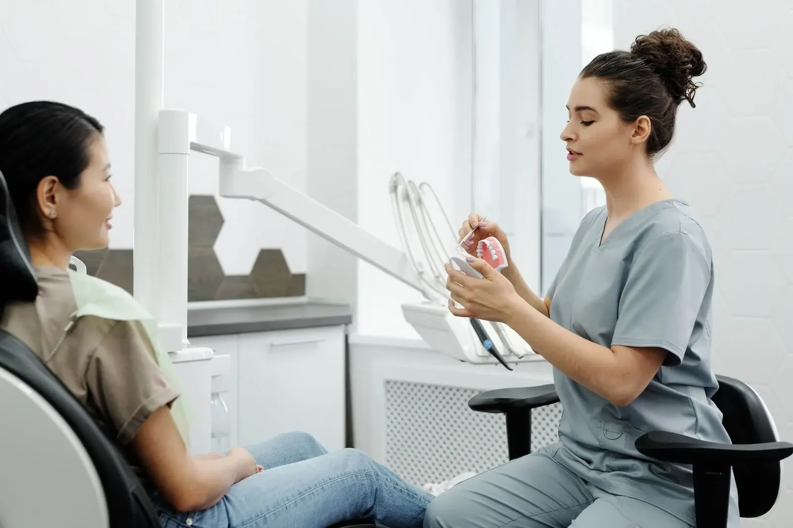 A dentist talking with a patient in the dental chair