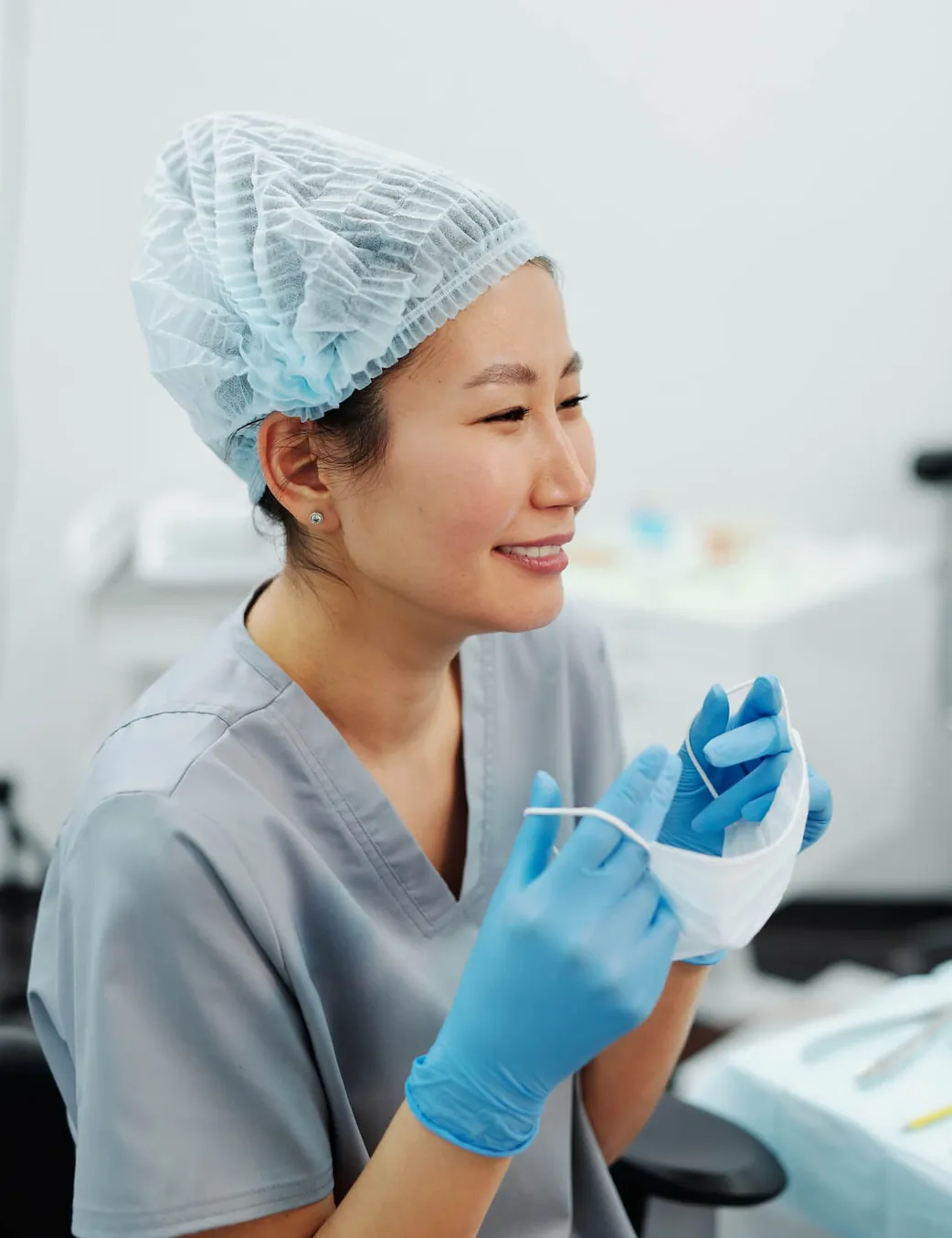 A dental assistant in blue gloves