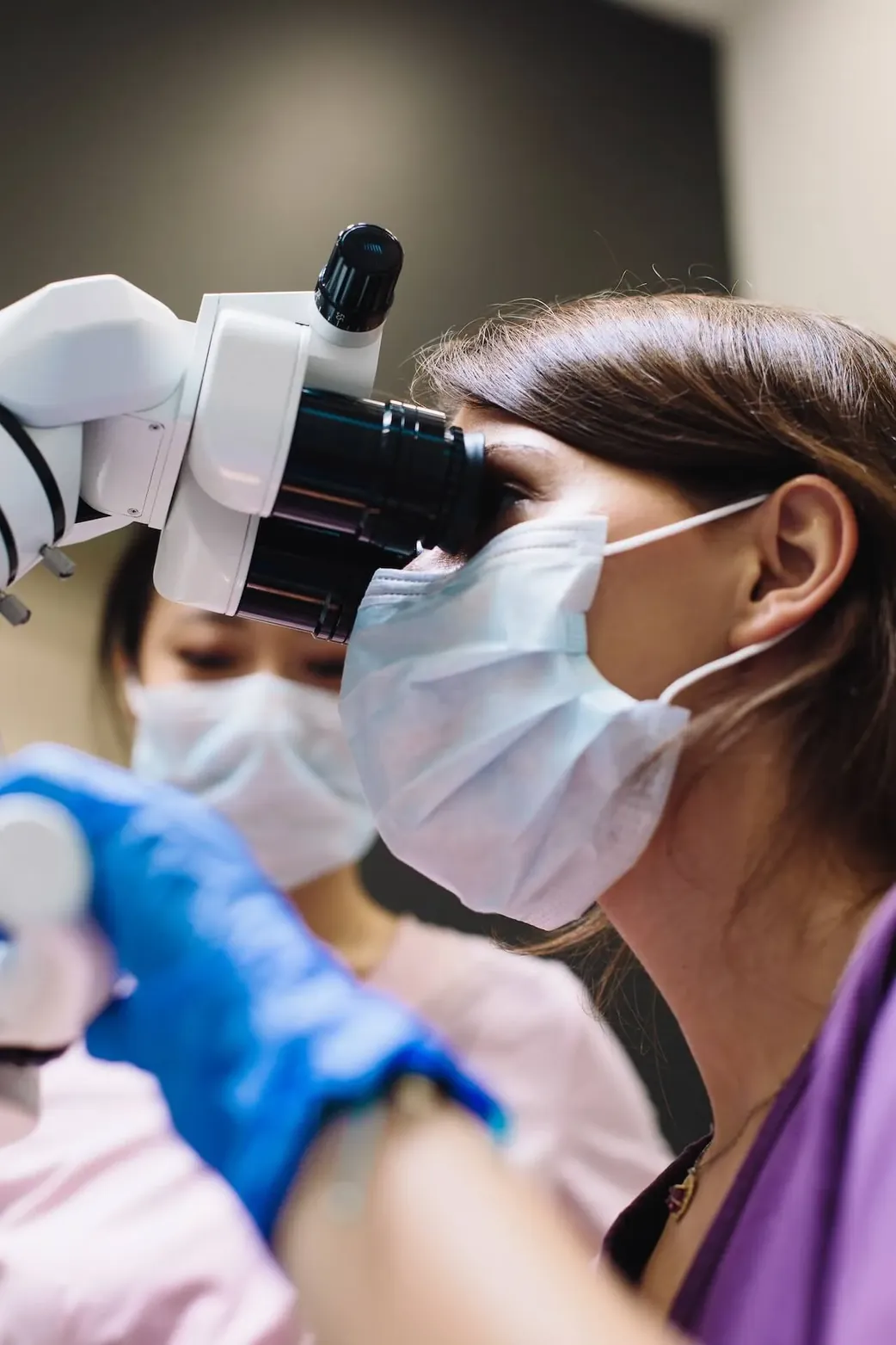 A dentist working with a microscope