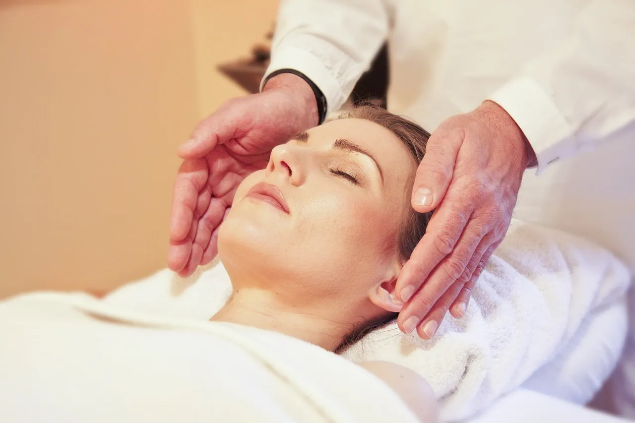 A woman relaxing with her eyes closed during a facial massage