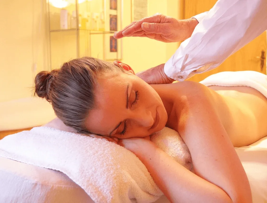 A woman enjoying a back massage in warm light