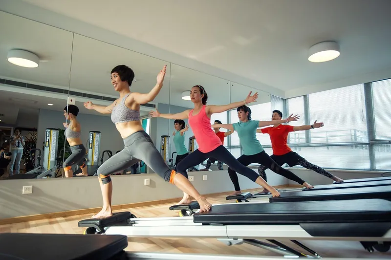 A group class stretching together in a bright studio