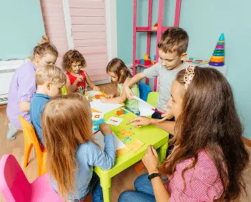 Three children in matching blue tops, laughing