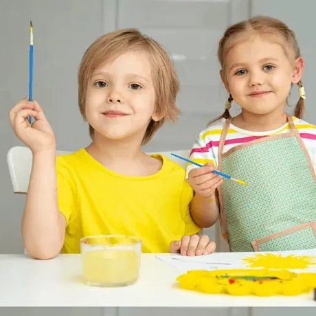 Two children painting at a table