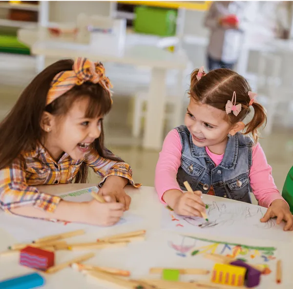 Two girls painting with watercolours